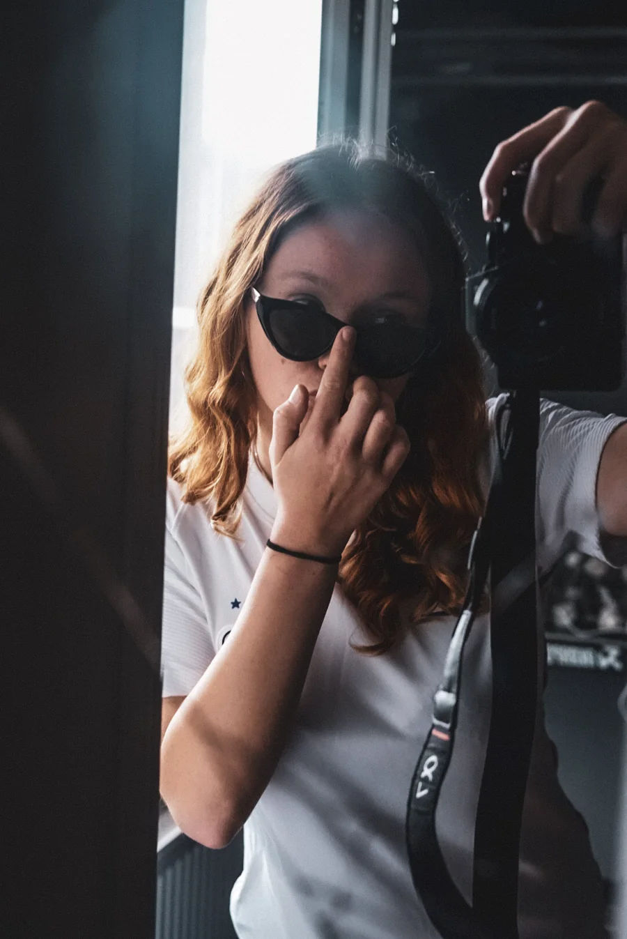 Lea mit Sonnenbrille und Kamera im Spiegel